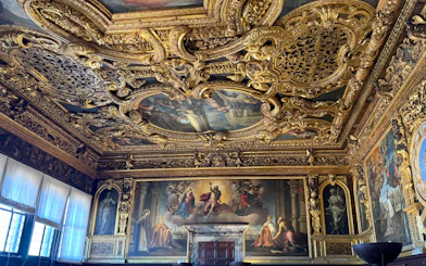Doge's Palace interior with ornate gilded ceiling and Renaissance paintings, Venice.