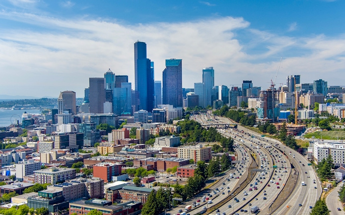 Seattle skyline with skyscrapers and highway, overlooking Elliot Bay.