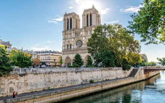 Notre-Dame Cathedral exterior on Île de la Cité, Paris, viewed from the Seine River.