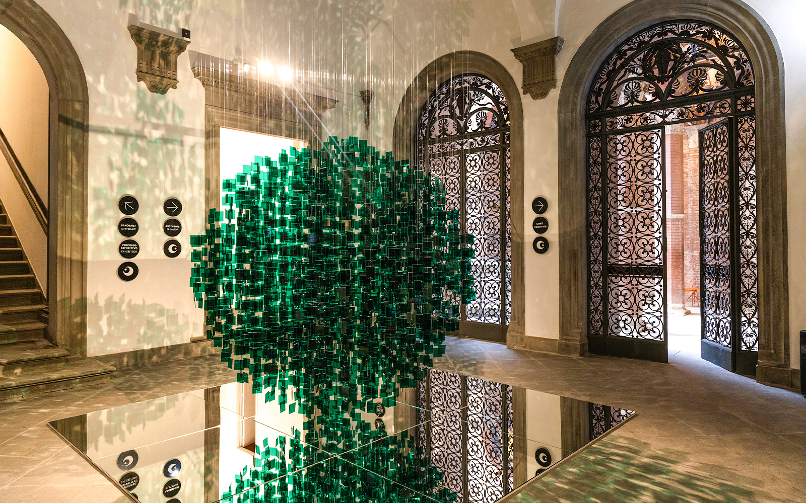 Palazzo delle Papesse interior with green art installation and ornate doors.