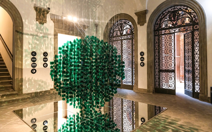 Palazzo delle Papesse interior with green art installation and ornate doors.