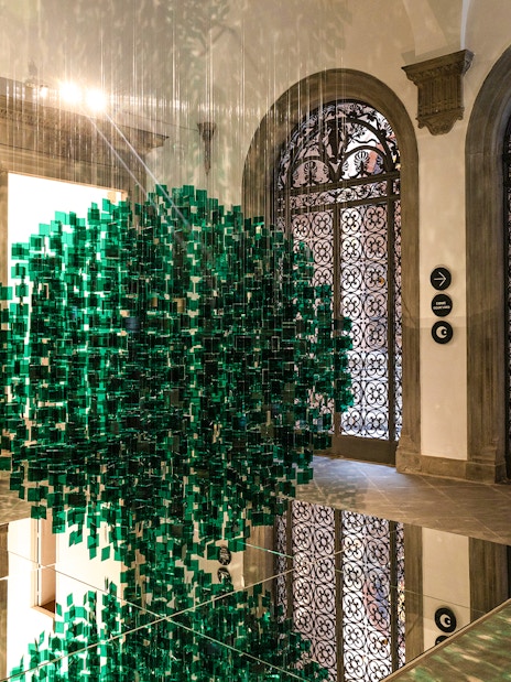 Palazzo delle Papesse interior with green art installation and ornate doors.