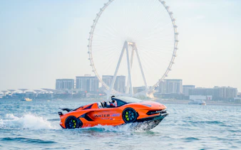 Jet car on water with Abu Dhabi skyline and Ferris wheel in the background.
