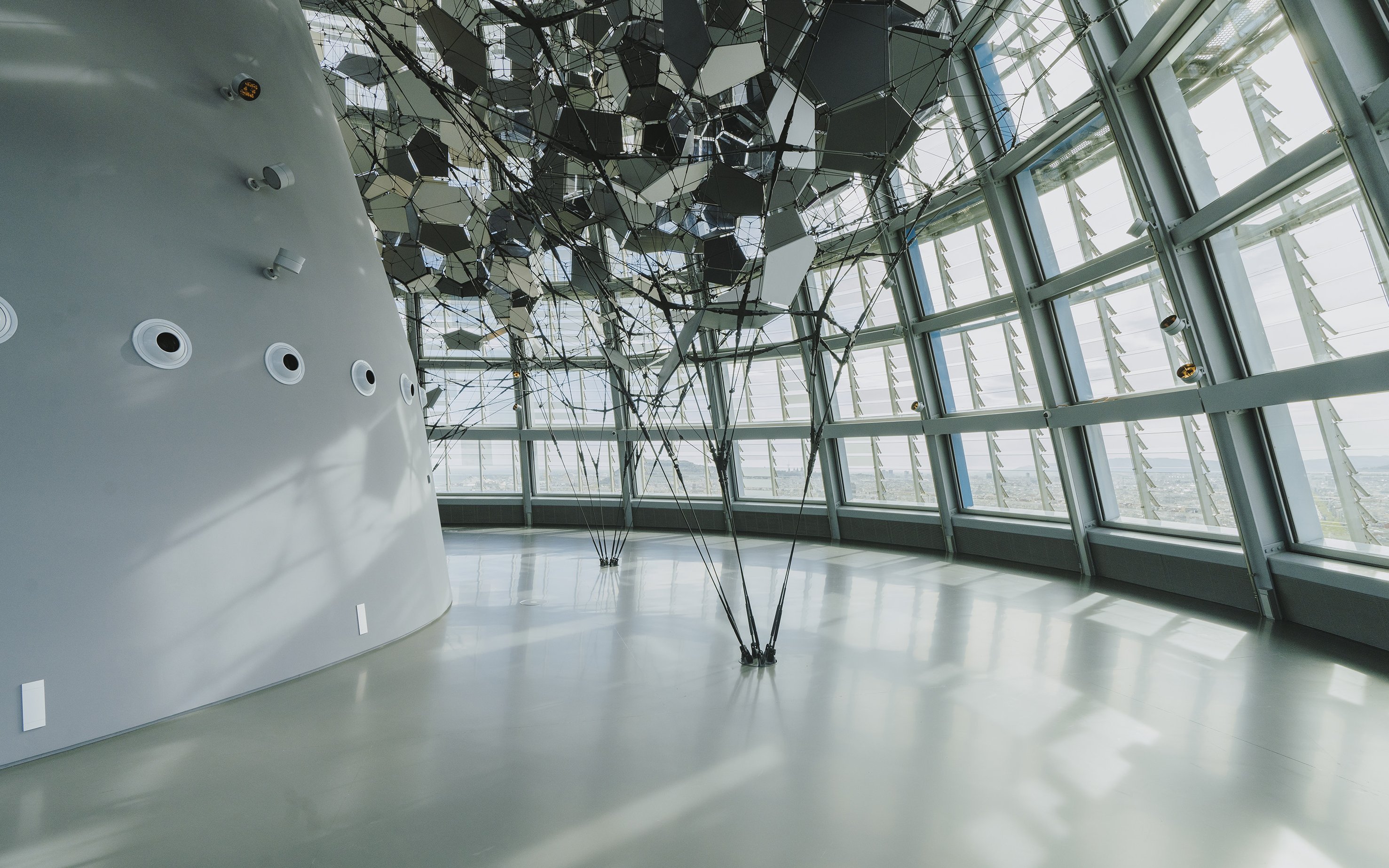 Interior view of Glories Skyline Tower with geometric ceiling design and large windows.