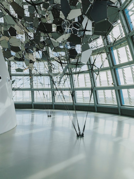 Interior view of Glories Skyline Tower with geometric ceiling design and large windows.