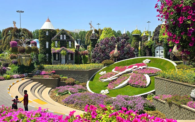 Floral clock surrounded by vibrant flowers at Dubai Miracle Garden.