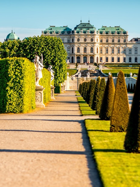 Upper Belvedere Palace gardens with statues and manicured hedges, Vienna.