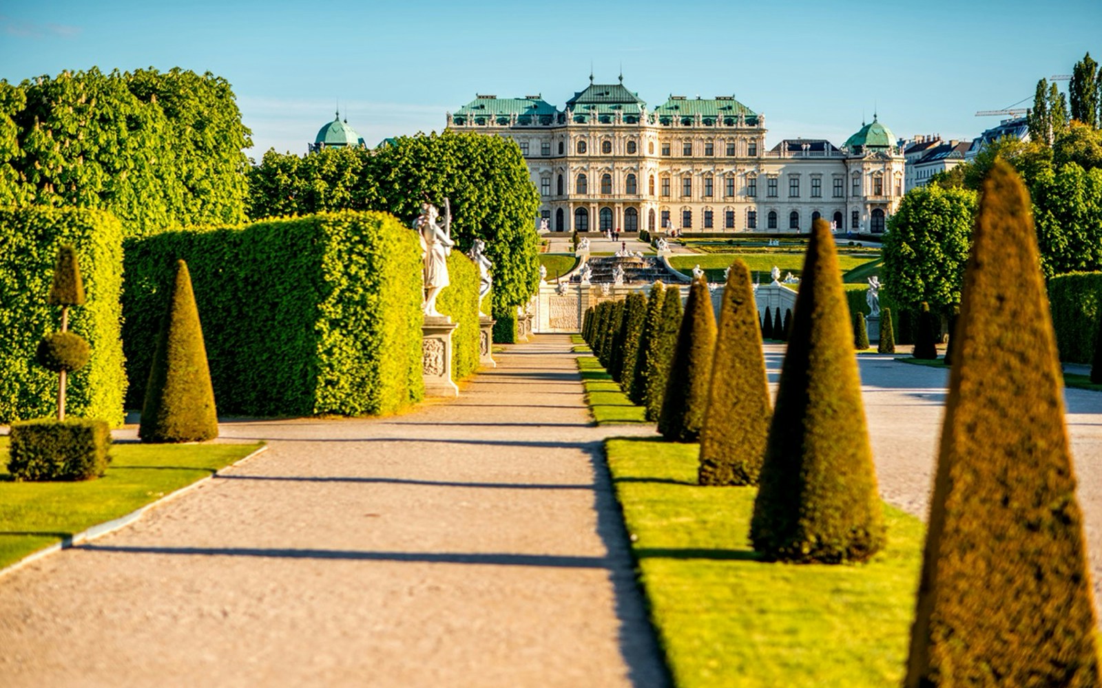 Upper Belvedere Palace gardens with statues and manicured hedges, Vienna.