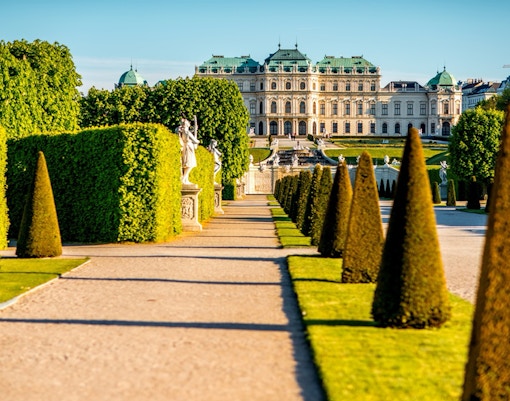 Upper Belvedere Palace gardens with statues and manicured hedges, Vienna.