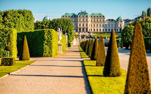 Upper Belvedere Palace gardens with statues and manicured hedges, Vienna.