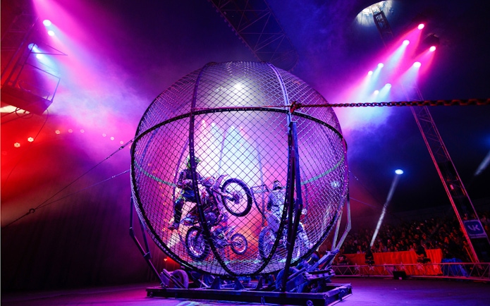 Motorcycle stunt inside a metal globe at Aqua Circus Phuket.