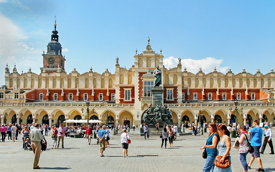 Krakow's Cloth Hall in Old Town with people walking nearby.