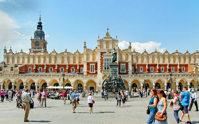 Krakow's Cloth Hall in Old Town with people walking nearby.