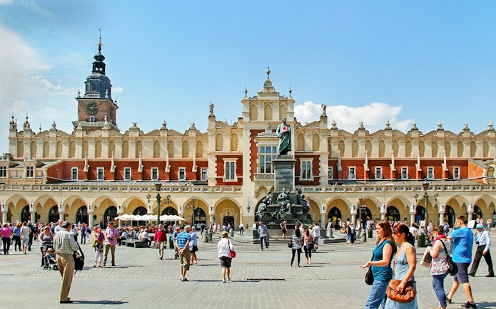 Krakow's Cloth Hall in Old Town with people walking nearby.