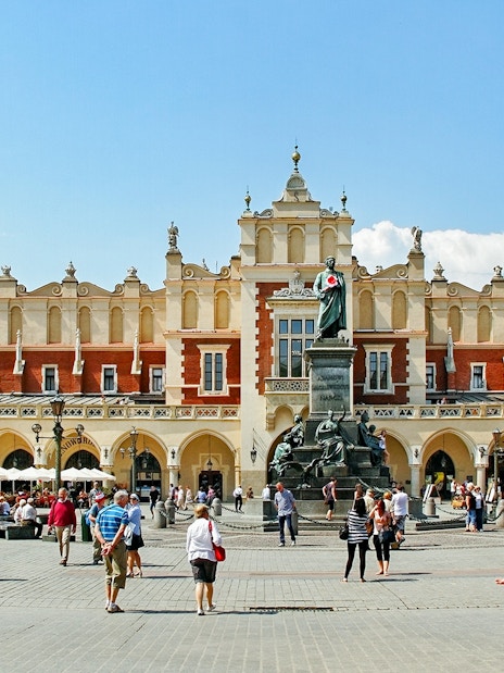 Krakow's Cloth Hall in Old Town with people walking nearby.