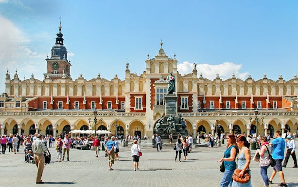 Krakow's Cloth Hall in Old Town with people walking nearby.
