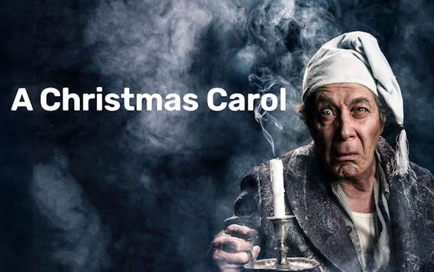 Man in nightcap holding candle, representing Scrooge from A Christmas Carol.