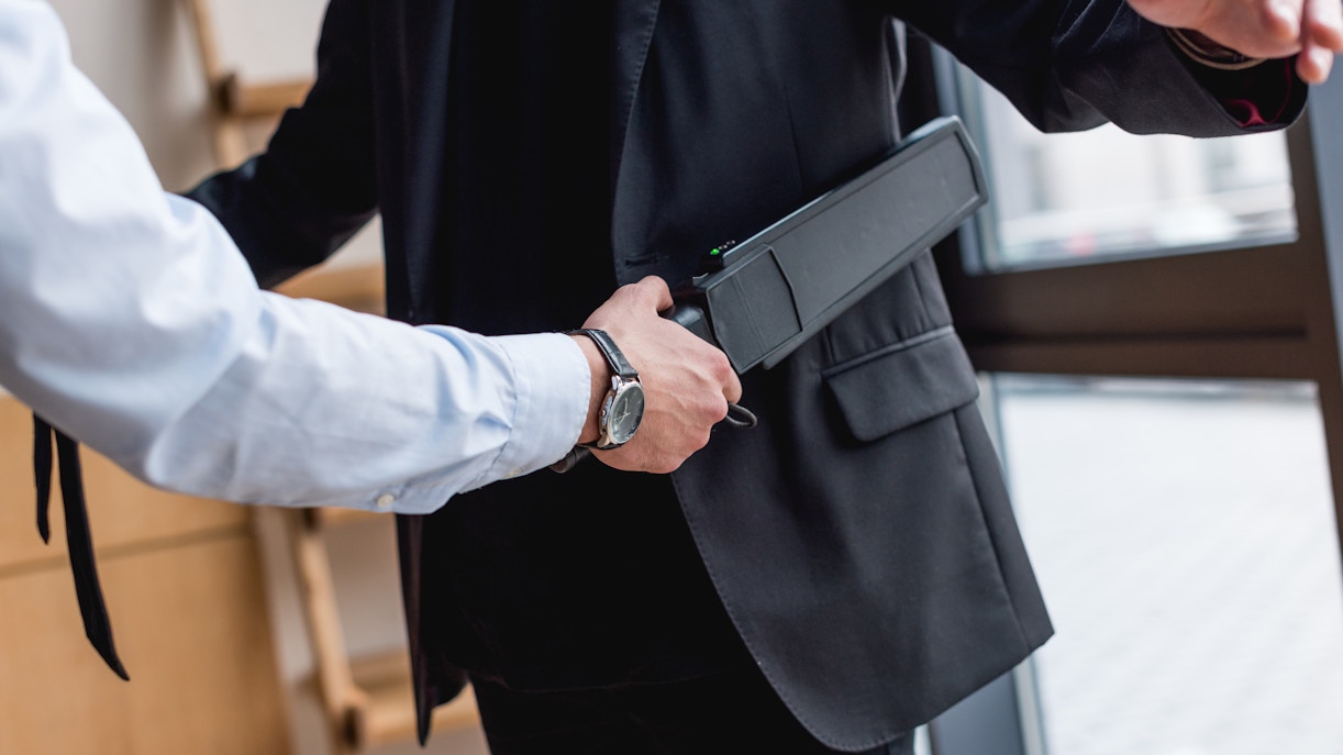 Security screening with handheld metal detector before tour.
