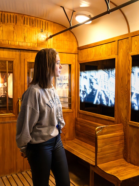 Train station exhibit inside Oskar Schindler's Factory with visitor watching historical footage.