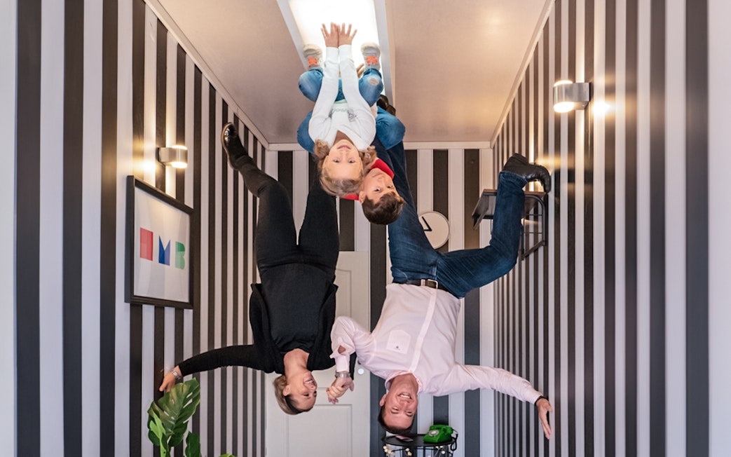 Visitors experiencing an upside-down room at Illuseum Berlin.