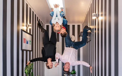 Visitors experiencing an upside-down room at Illuseum Berlin.