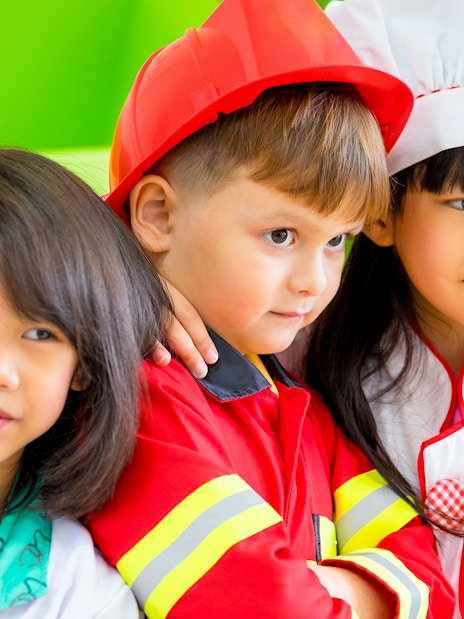Children in costumes at KidsSTOP Singapore interactive exhibit.