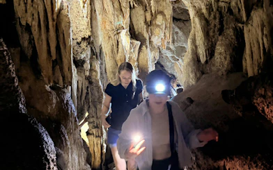 Visitors exploring Diamond Cave with headlamps on the Cheow Lan Lake tour in Krabi.