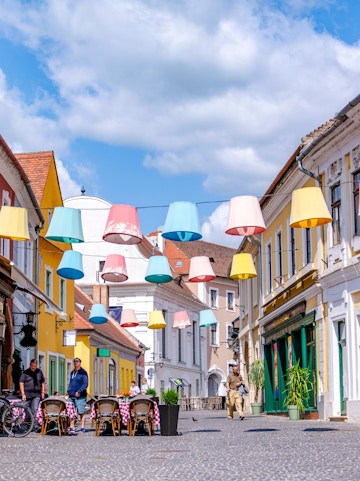 Colorful lampions hanging over a cobblestone street in Szentendre, Hungary's old town.