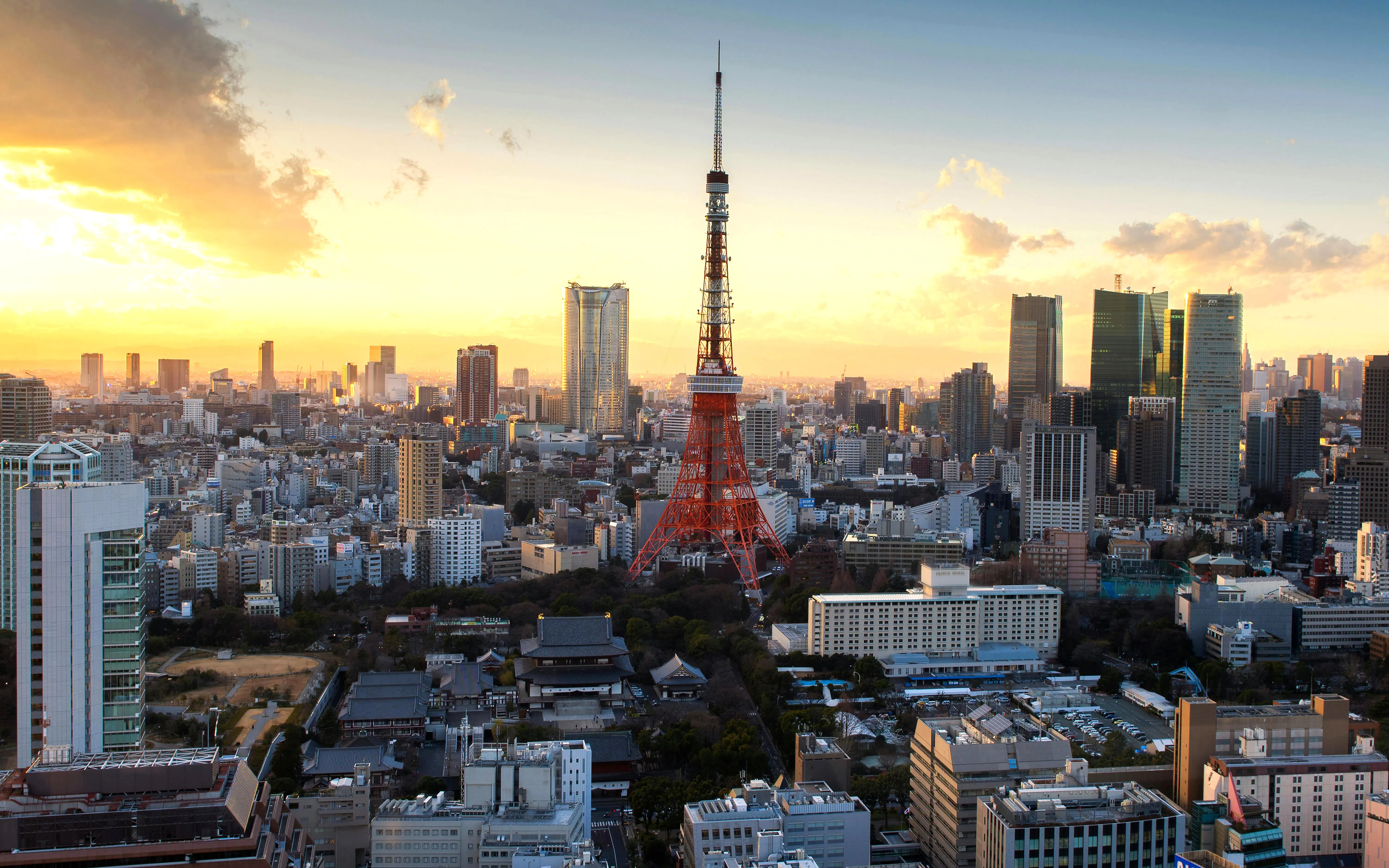 Tokyo Tower surrounded by cityscape at sunset.