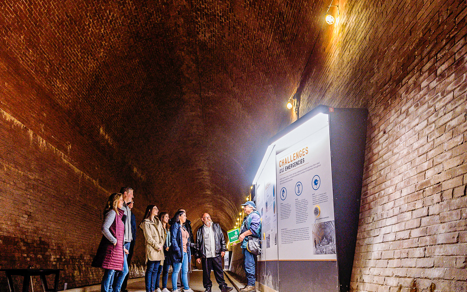 Visitors in a tunnel at Niagara Falls, viewing an informational display.