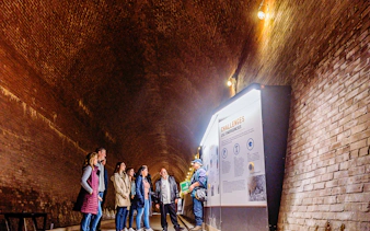 Visitors in a tunnel at Niagara Falls, viewing an informational display.