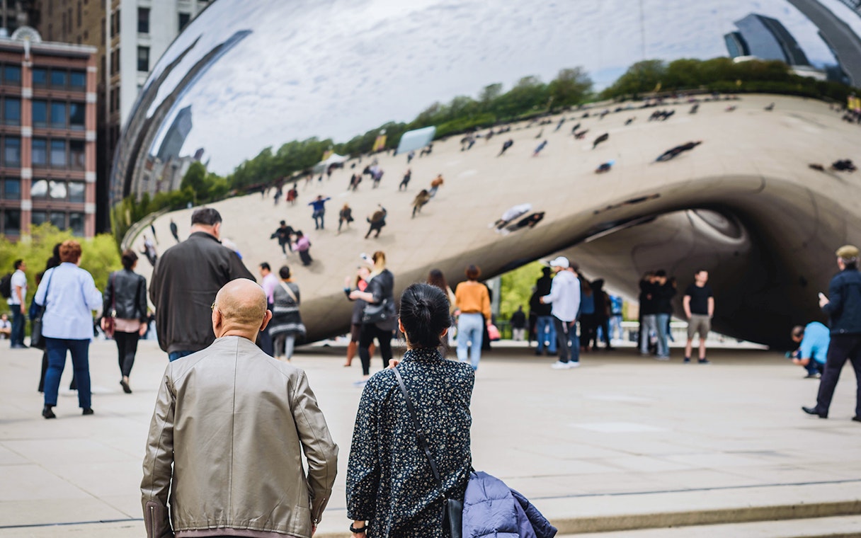 Guests exploring Cloud Gate sculpture in Chicago during Skydeck and Architecture Cruise tour.
