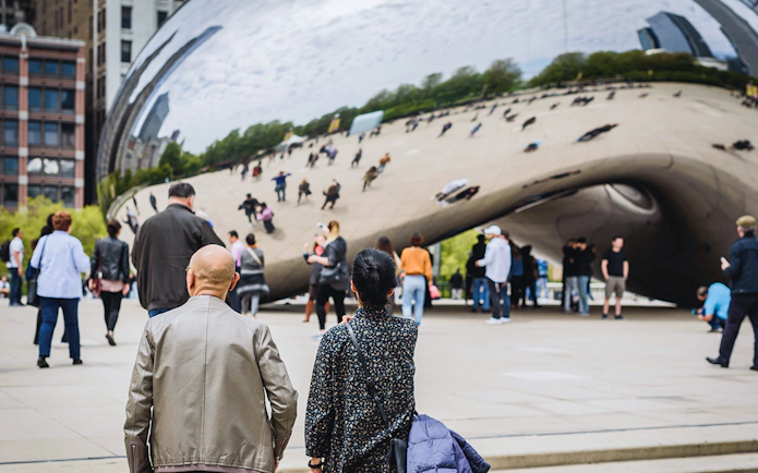 Guests exploring Cloud Gate sculpture in Chicago during Skydeck and Architecture Cruise tour.