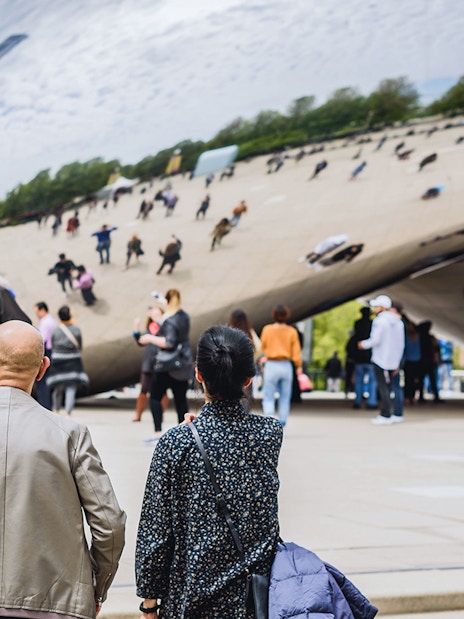 Guests exploring Cloud Gate sculpture in Chicago during Skydeck and Architecture Cruise tour.