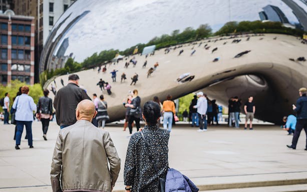Guests exploring Cloud Gate sculpture in Chicago during Skydeck and Architecture Cruise tour.