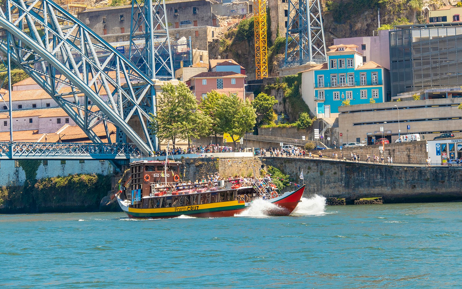 Tour boat on Douro River near Dom Luís I Bridge in Porto, Portugal.