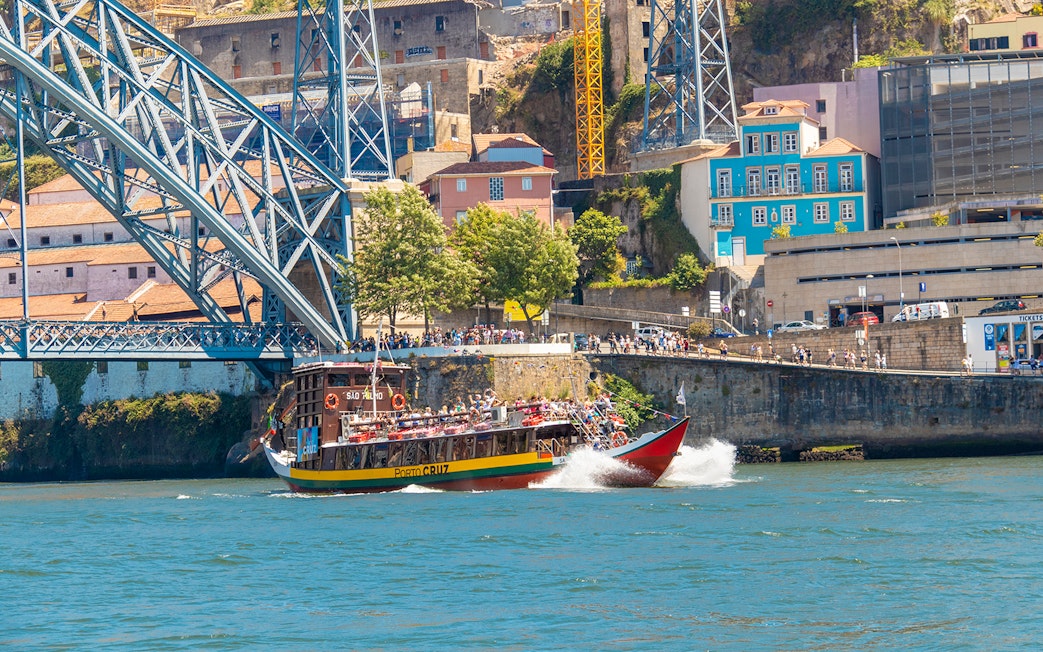 Tour boat on Douro River near Dom Luís I Bridge in Porto, Portugal.