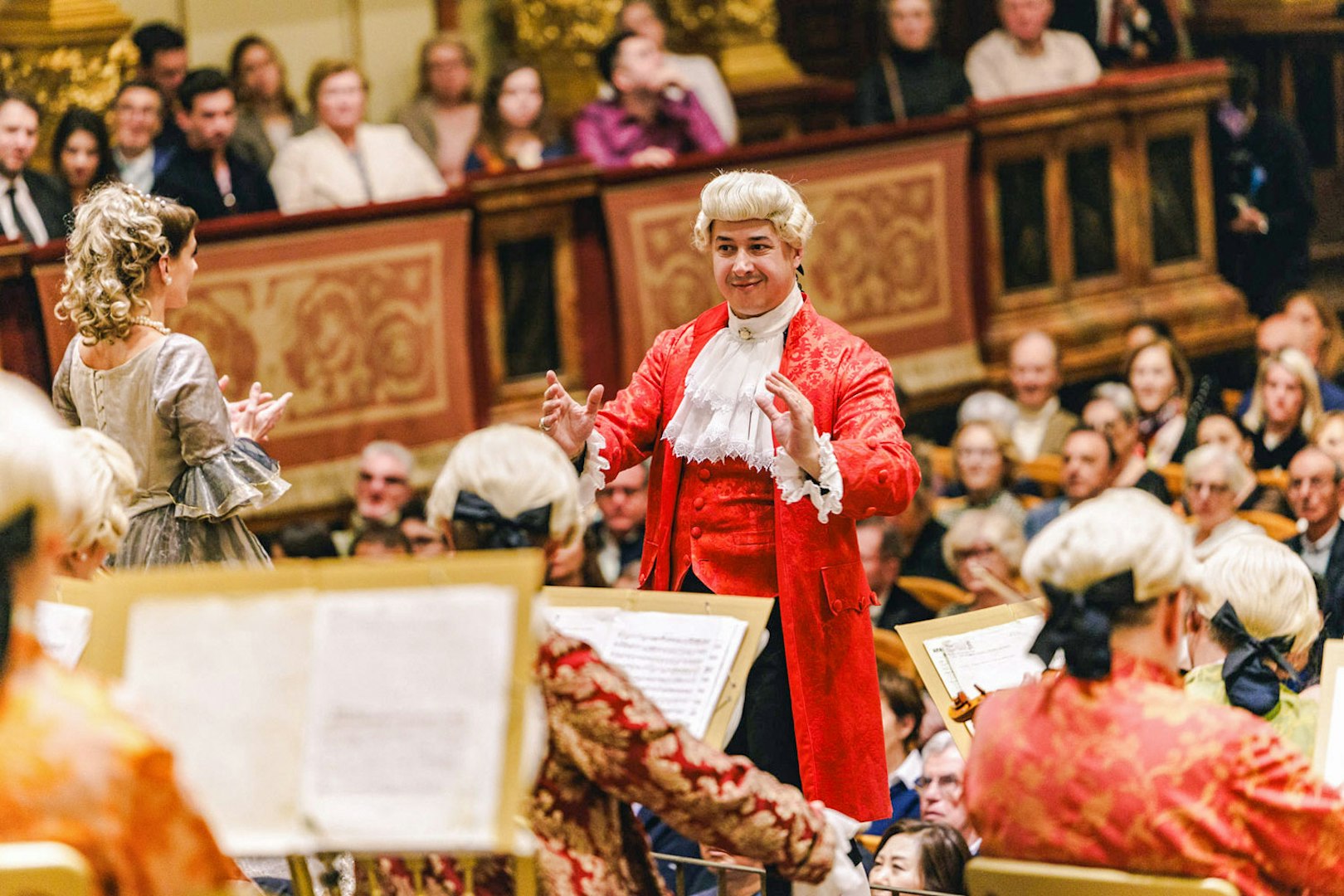 Mozart Orchestra performing in Vienna's Golden Hall with audience in period attire.