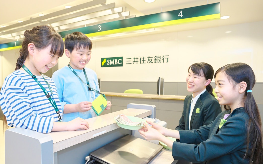 Children role-playing as bank tellers at KidZania Tokyo.