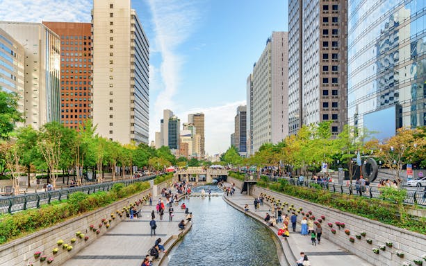 Cheonggyecheon Stream in Seoul with people walking along the waterway.