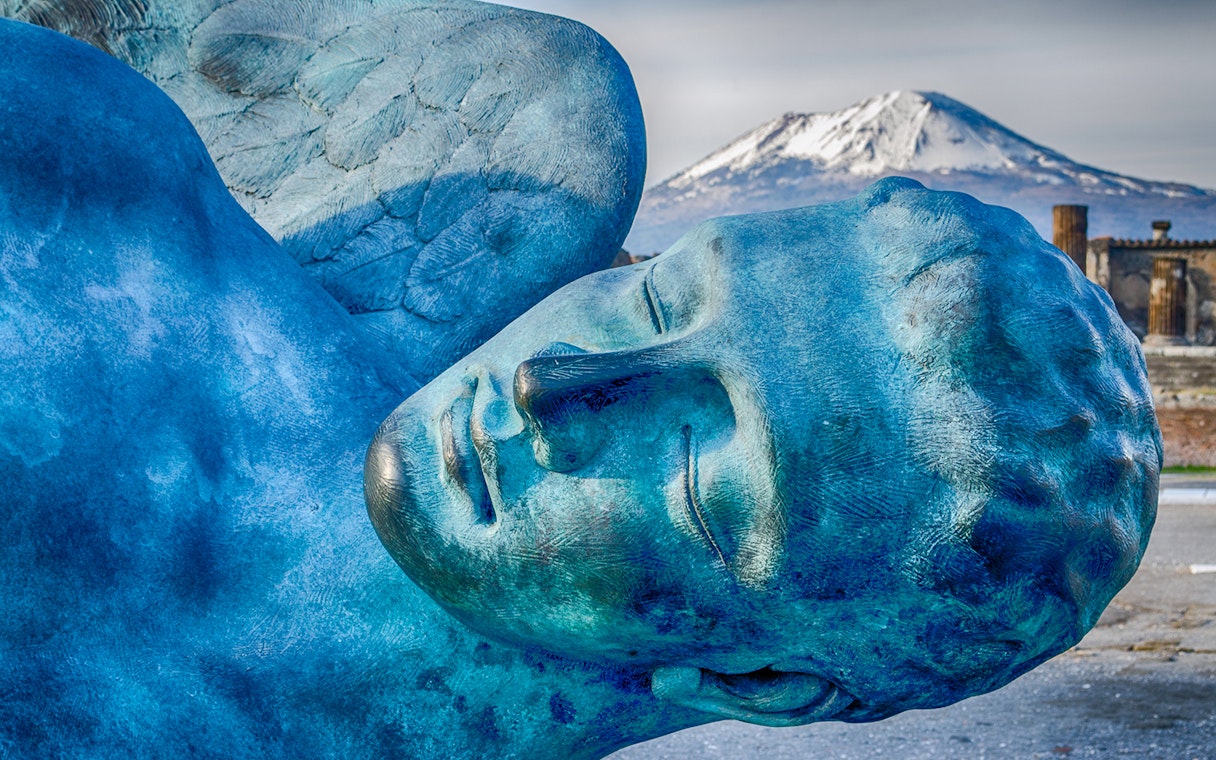 Sculpture in Pompeii with Mount Vesuvius in the background.