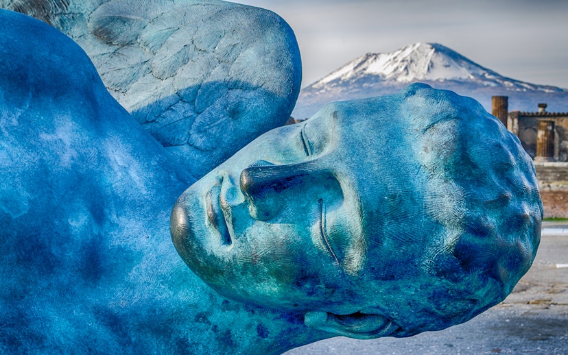 Sculpture in Pompeii with Mount Vesuvius in the background.