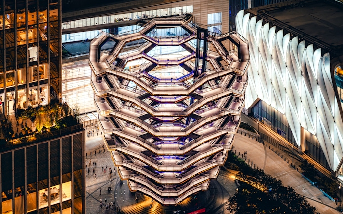 Vessel structure in New York City illuminated at night, viewed from above.