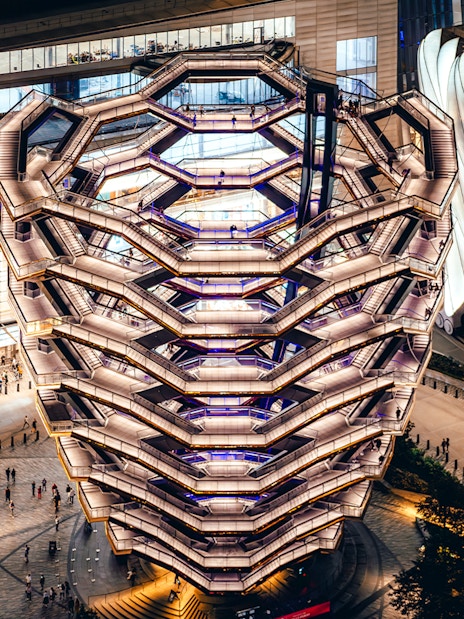 Vessel structure in New York City illuminated at night, viewed from above.