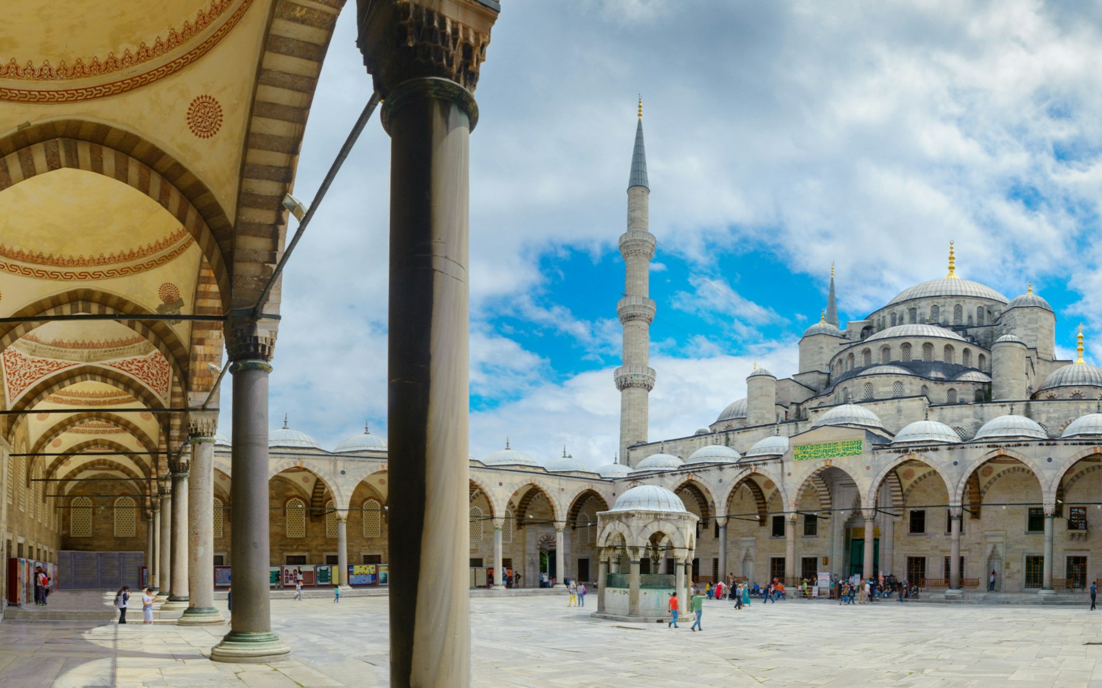 Courtyard of the Blue Mosque in Istanbul with arches and central fountain.
