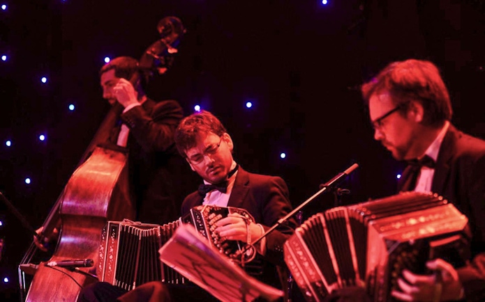 Musicians performing tango at El Viejo Almacén with bandoneons and double bass.