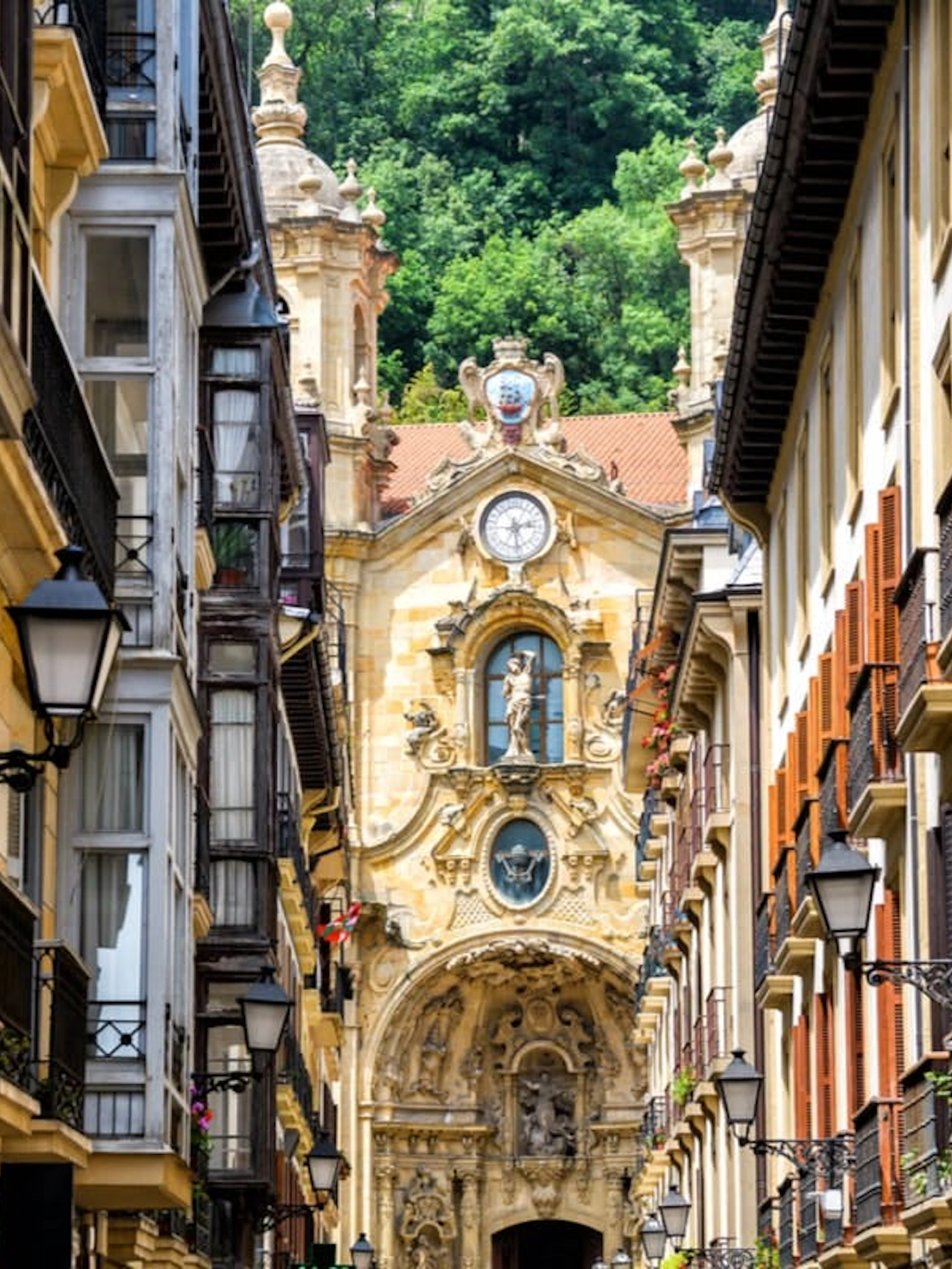 Narrow street in San Sebastian with view of Baroque church facade.