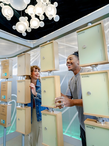 Friends exploring scent display at World of Coca-Cola Museum, Atlanta.