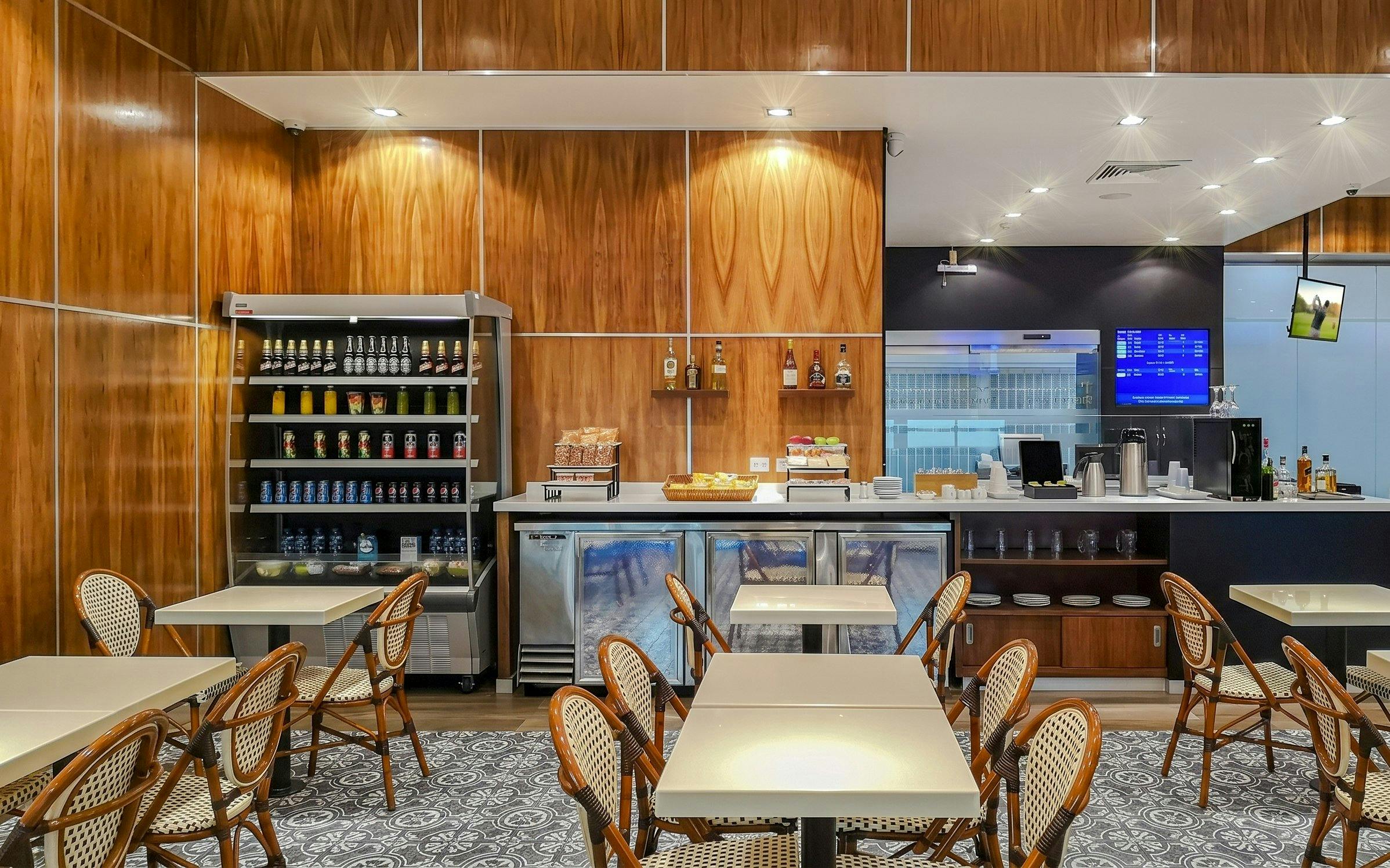 MERA Business Lounge seating area with refreshments at Cancún International Airport Terminal 2.