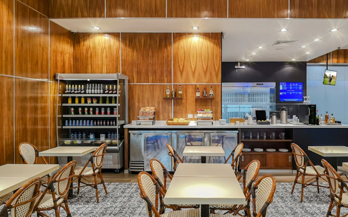 MERA Business Lounge seating area with refreshments at Cancún International Airport Terminal 2.
